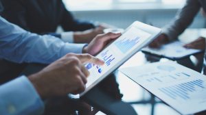 Image of businessperson pointing at document in touchpad at meeting